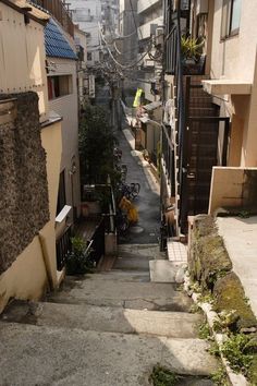 an alleyway with stairs leading up to buildings