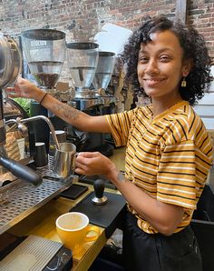 a woman is smiling as she pours her coffee from the espresso machine