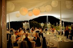 a group of people sitting at tables in a tent