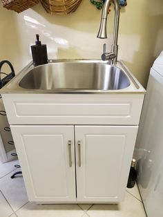 a kitchen sink with cupboards and a dishwasher in the corner next to it