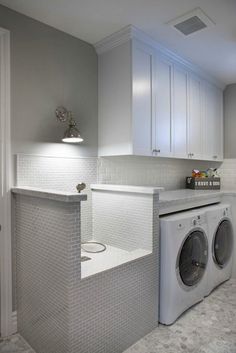 a washer and dryer in a white laundry room with gray tile flooring