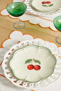 a table topped with plates and bowls filled with cherries