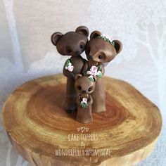 two brown bears with flowers on their heads are sitting on a tree stump in front of a white wall