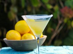 a martini glass with lemons in the background