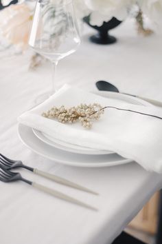 the table is set with white plates and silverware