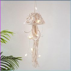 a chandelier hanging from the ceiling in a room with a potted plant