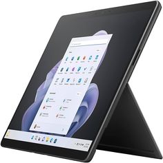 an open laptop computer sitting on top of a white table next to a black tablet