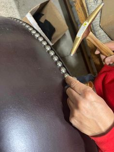 a person is working on a piece of furniture with a pair of wood mallets