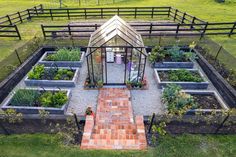 an aerial view of a vegetable garden in a fenced off area with lots of plants