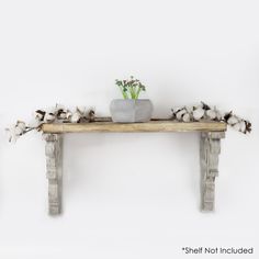 a wooden table topped with a potted plant and cotton