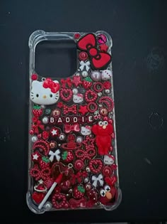 a cell phone case with hello kitty and other items on the back, sitting on a table