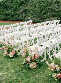 rows of white chairs with pink flowers on them