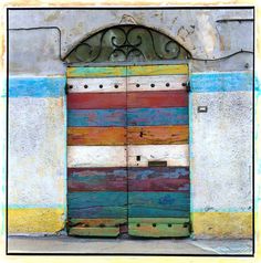 an old wooden door painted with multicolored paint