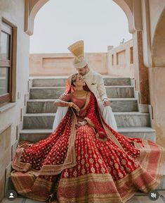 a bride and groom posing on the stairs at their wedding