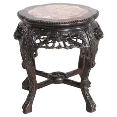 an ornate wooden stool with marble top