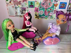 three dolls sitting on top of a table next to each other