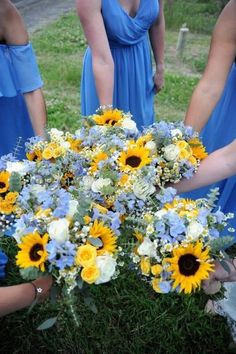 the bridesmaids are wearing blue dresses and holding bouquets of sunflowers