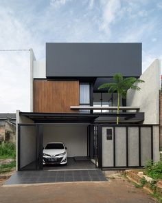 a white car is parked in front of a modern house with an open garage door