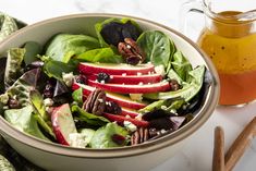 a salad in a bowl with apples and pecans