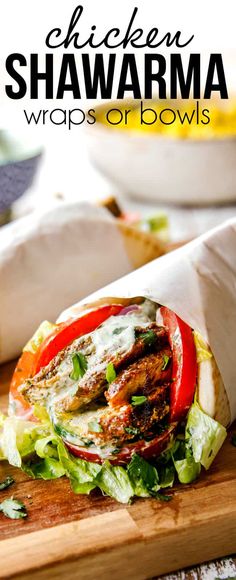 chicken shawarma wraps with lettuce and tomatoes on a wooden cutting board