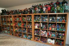 the shelves are filled with many different types of action figures and toys on display in this room