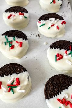 cookies decorated with white frosting and chocolate chips in the shape of a snowman