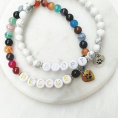 "Listing is for one (1) bracelet containing 6mm beads gold/silver letter beads, and accented with matching spacer beads and paw print charm. Charm says \"heart my dog\" or \"heart my cat\" on the backside. 20% of proceeds from the sale of this bracelet will benefit animal shelters/pet rescues. More information can be found here: www.weau.com/wagnertails This bracelet is NOT recommended for pets to wear. This bracelet stretches to fit small to medium sized wrists (approximately 7 inches long). Si Personalized Spiritual Beaded Bracelets As Best Friend Gift, Pet Jewelry, Animal Bracelet, Paw Print Charm, Animal Shelters, Dana Point, Moms Bracelet, Jewelry Beaded, Letter Beads