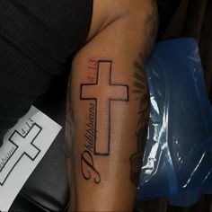 a man with a cross tattoo on his arm