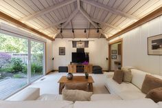 a living room filled with furniture and a flat screen tv on top of a wooden table