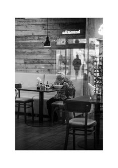 a man sitting at a table in front of a window