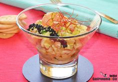 a glass bowl filled with food sitting on top of a table next to crackers