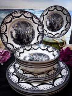 a stack of black and white plates sitting next to each other on top of a table