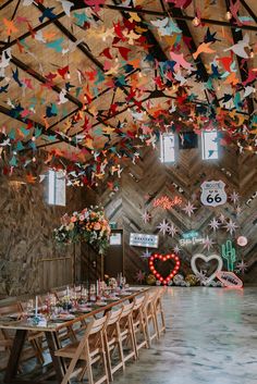 a room filled with lots of tables covered in paper cranes hanging from the ceiling above them