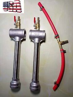 two red hoses are attached to the side of a metal pipe and one is connected to