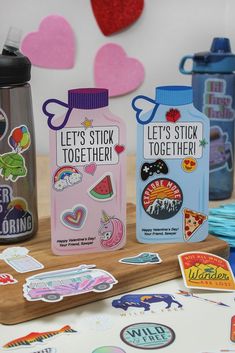 several stickers and magnets are displayed on a wooden table with hearts in the background