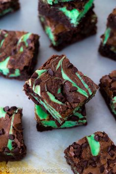 there are many brownies that have green frosting on them and chocolate chips in the middle