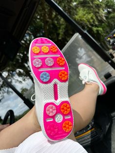 a close up of a person's foot wearing pink and white shoes