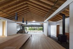 an empty room with wood flooring and wooden beams on the ceiling, along with a car parked in the garage