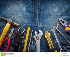 various tools are laid out in the back pocket of a pair of blue jeans,