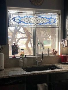 a kitchen sink under a stained glass window