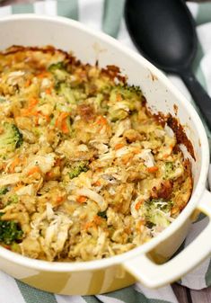 a casserole dish with broccoli, carrots and chicken in it