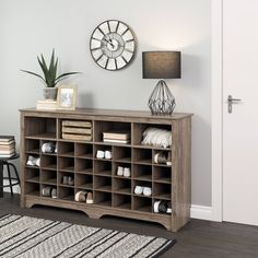 a large wooden shelf with many pairs of shoes on it in front of a clock