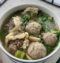 a white bowl filled with meat and vegetable soup