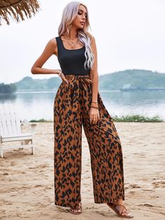 Introducing our bold and playful Graphic Print Wide Leg Belted Jumpsuit, perfect for making a statement. The black sleeveless top and leopard print bottom create a striking contrast, making this jumpsuit both fun and fashionable. The wide-leg design provides comfort and ease of movement, while the included belt cinches in at the waist for a flattering silhouette. Whether dressed up or down, this jumpsuit is sure to turn heads and elevate your style. Specification: Style: Casual Pattern Type: Gra Sleeveless Leopard Print Jumpsuits And Rompers For Summer, Sleeveless Leopard Print Jumpsuit For Summer, Chic Sleeveless Leopard Print Jumpsuit, Casual Leopard Print Jumpsuits And Rompers For Party, Black Wide-leg Jumpsuits And Rompers For Summer, Black Wide Leg Jumpsuits And Rompers For Vacation, Black Wide Leg Jumpsuits And Rompers For Beach, Comfy Jumpsuits, Belted Jumpsuit