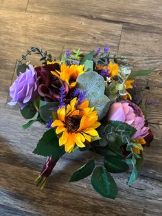 a bouquet of flowers sitting on top of a wooden table