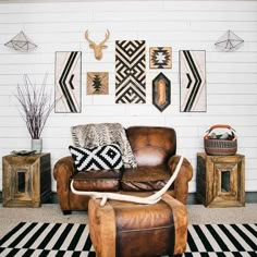 a brown leather chair sitting in front of a white wall with pictures on the wall