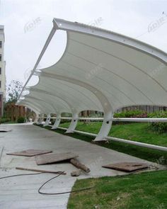 an outdoor covered walkway in the middle of a park