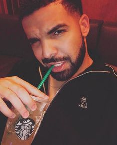 a man with a starbucks drink and a straw in his mouth