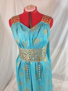 a mannequin wearing a blue dress with gold accents