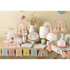 a table topped with lots of cakes and cupcakes next to a cake stand